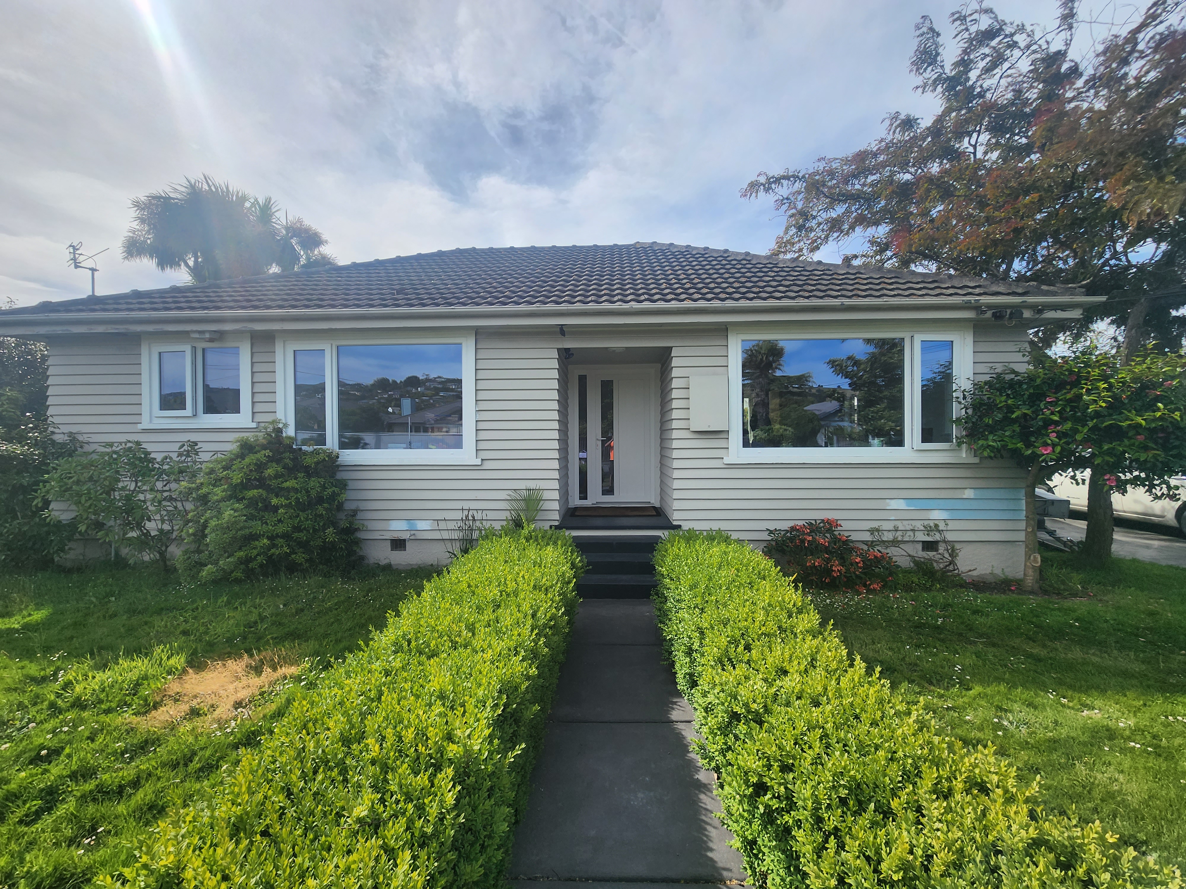 Weatherboard home refitted with white uPVC windows and entrance door