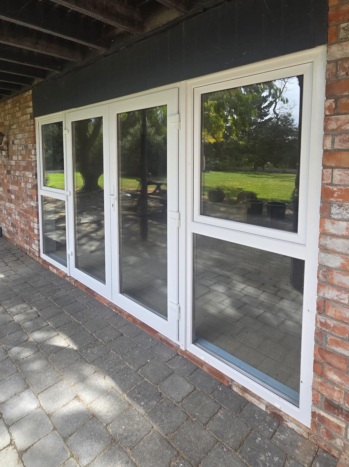 uPVC French doors and side window fitted to a brick home overlooking a garden